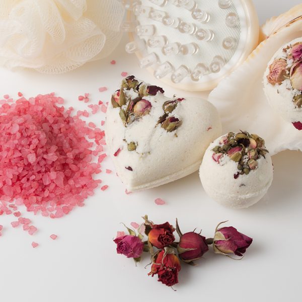 Bomb salt bath decorated with dried roses on a white background